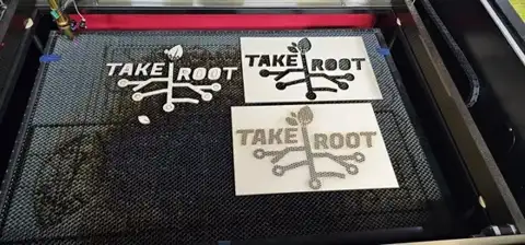 Take Root signs on the laser bed
