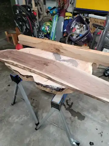 Live-edge boards stacked on sawhorses
