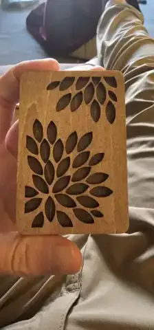 Small wood piece with a cut-out leaf tree in a hand