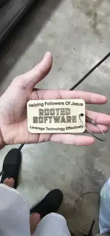 Small Rooted Software wood tag in a hand