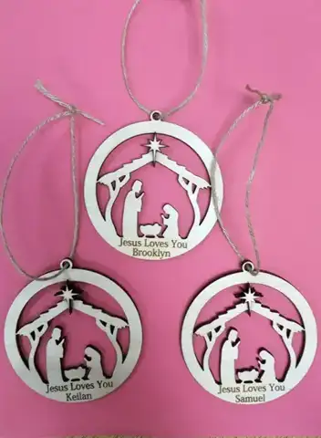 Three nativity ornaments with names on a pink background
