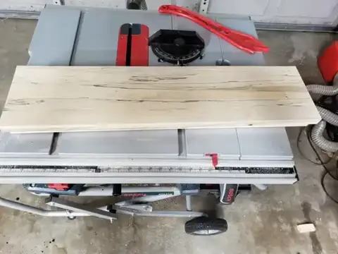 Planed light wood board on a table saw