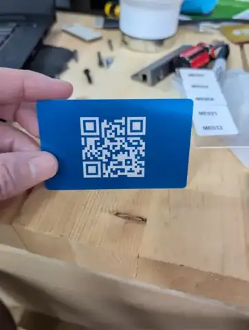 Blue metal card with a QR code in a hand
